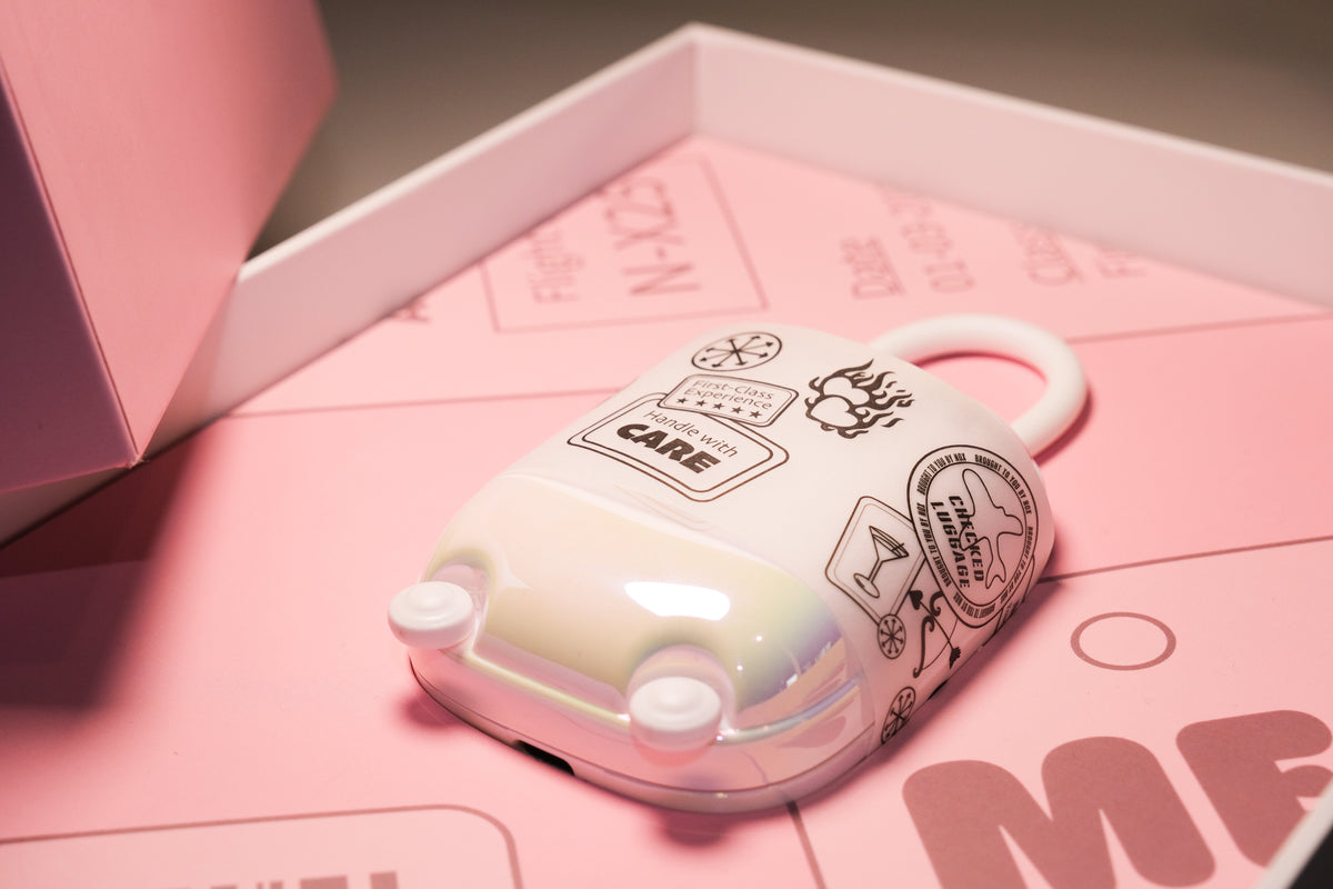 Aesthetic pastel flatlay of a nightstand-style self-care set, including the NOX Traveller suitcase-style charging case