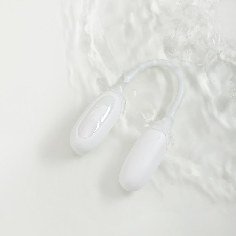 The white NOX Traveller beginner vibrator submerged in clear water, demonstrating its waterproof feature.