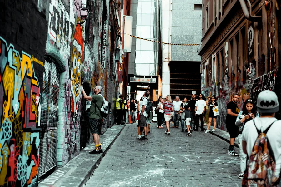 A street artist working in a graffiti-covered Melbourne laneway